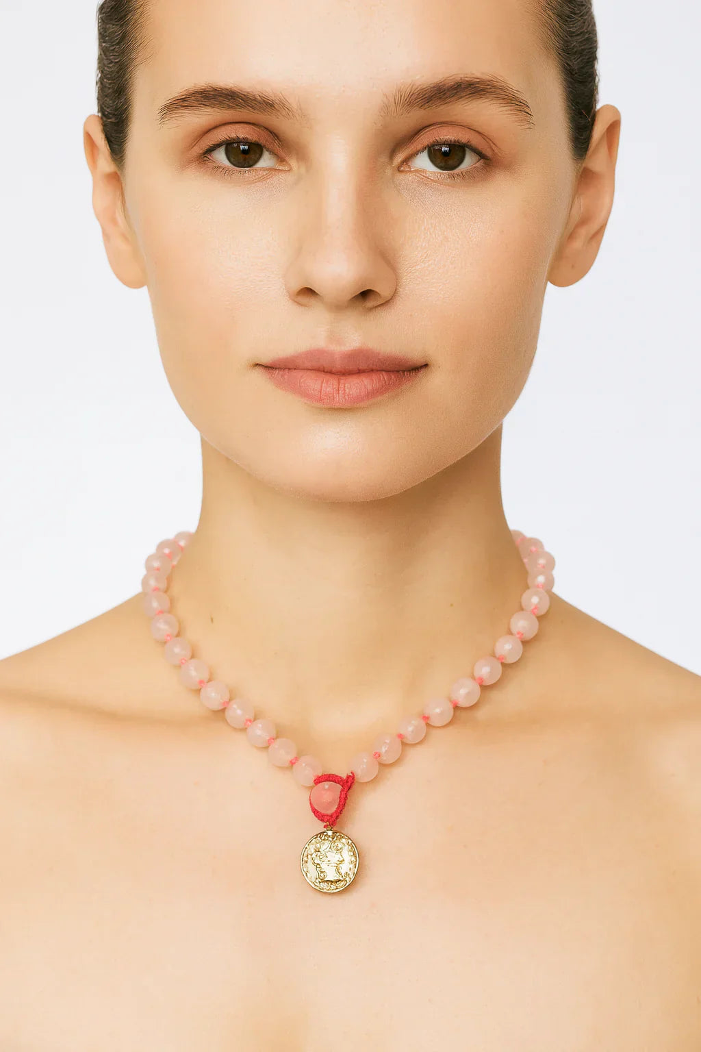 Woman in 40s wearing rose quartz necklace 