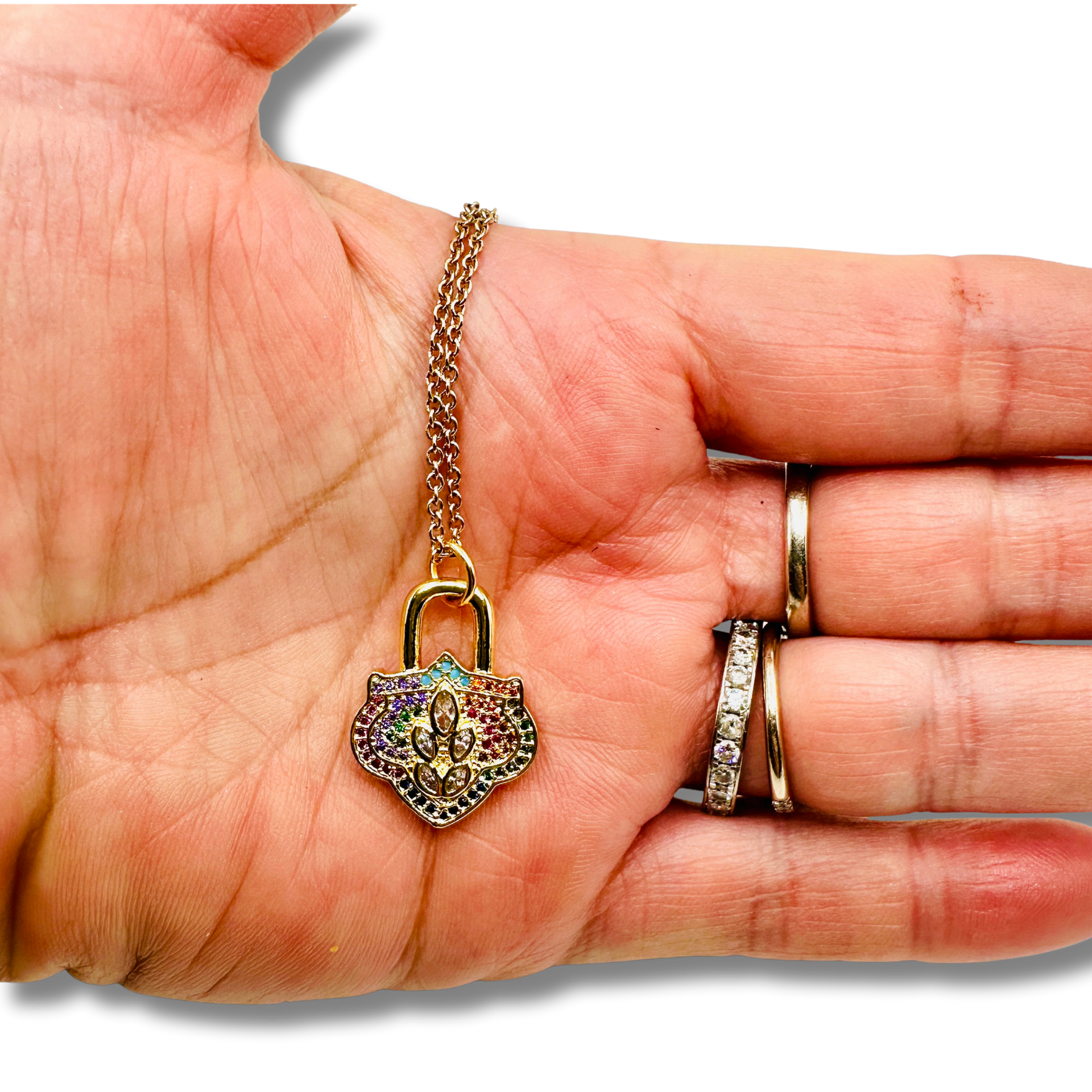 Gold chain with a multicolored padlock pendant held in a hand.