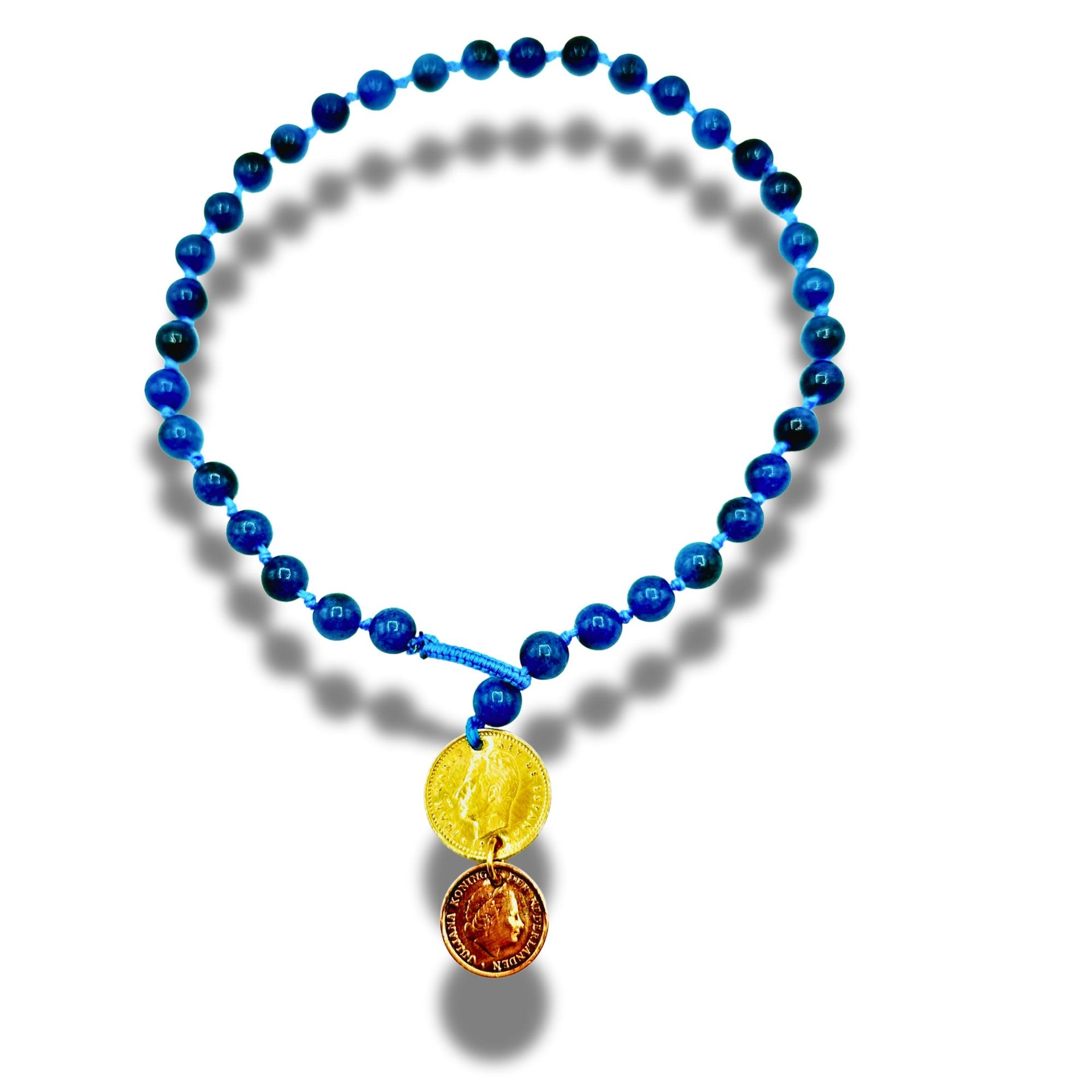Blue beaded necklace with two coins on a white background