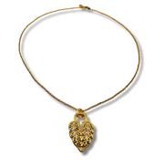 Gold necklace with a heart-shaped pendant on a white background