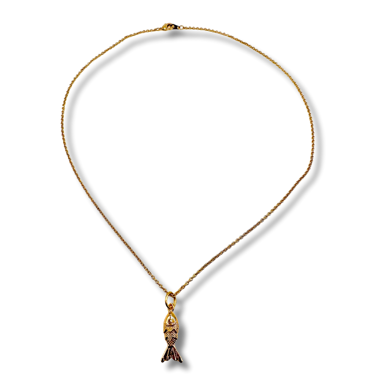 Gold necklace with a fish pendant on a white background