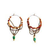 Pair of beaded earrings with gold chains and green gemstones on a white background