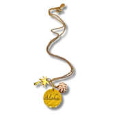 Gold necklace with 'Aloha' pendant and beach-themed charms on a white background