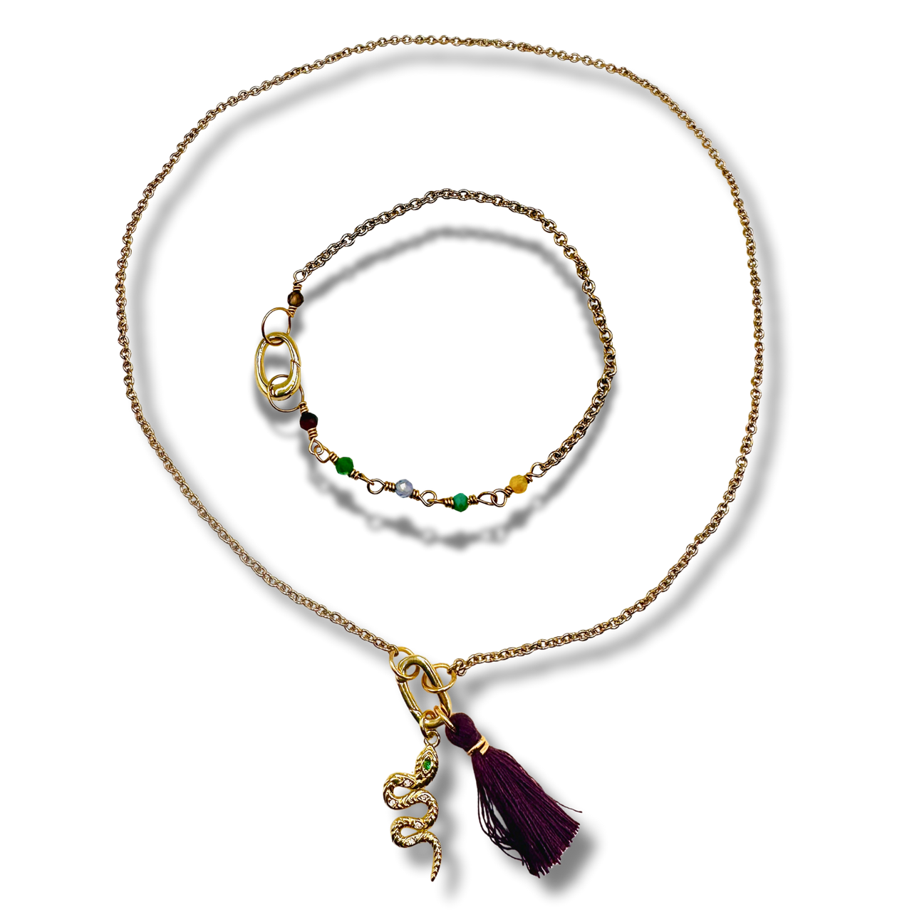 Gold necklace with a tassel pendant on a white background