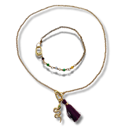 Gold necklace with a tassel pendant on a white background