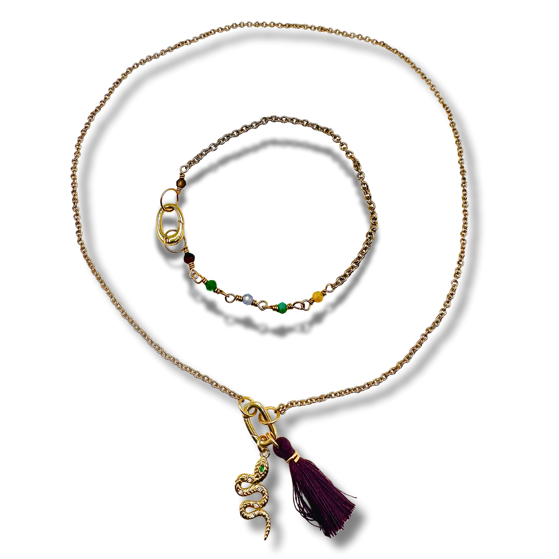 Gold necklace with a tassel pendant on a white background