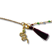 Gold necklace with snake charm and tassel on a white background