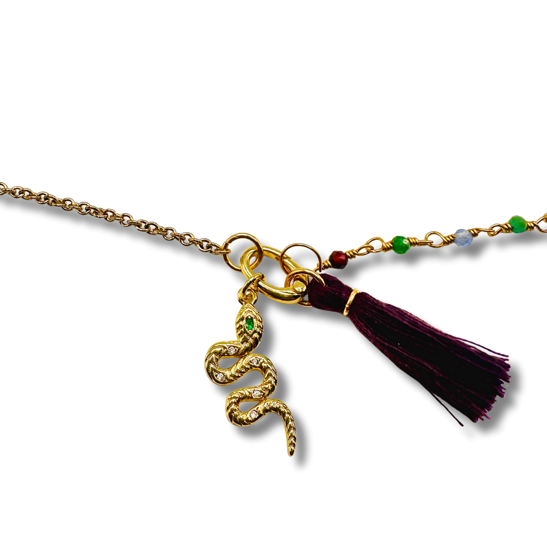 Gold necklace with snake charm and tassel on a white background