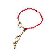 Bracelet with red cord, gold chain, and pearl charms on a white background