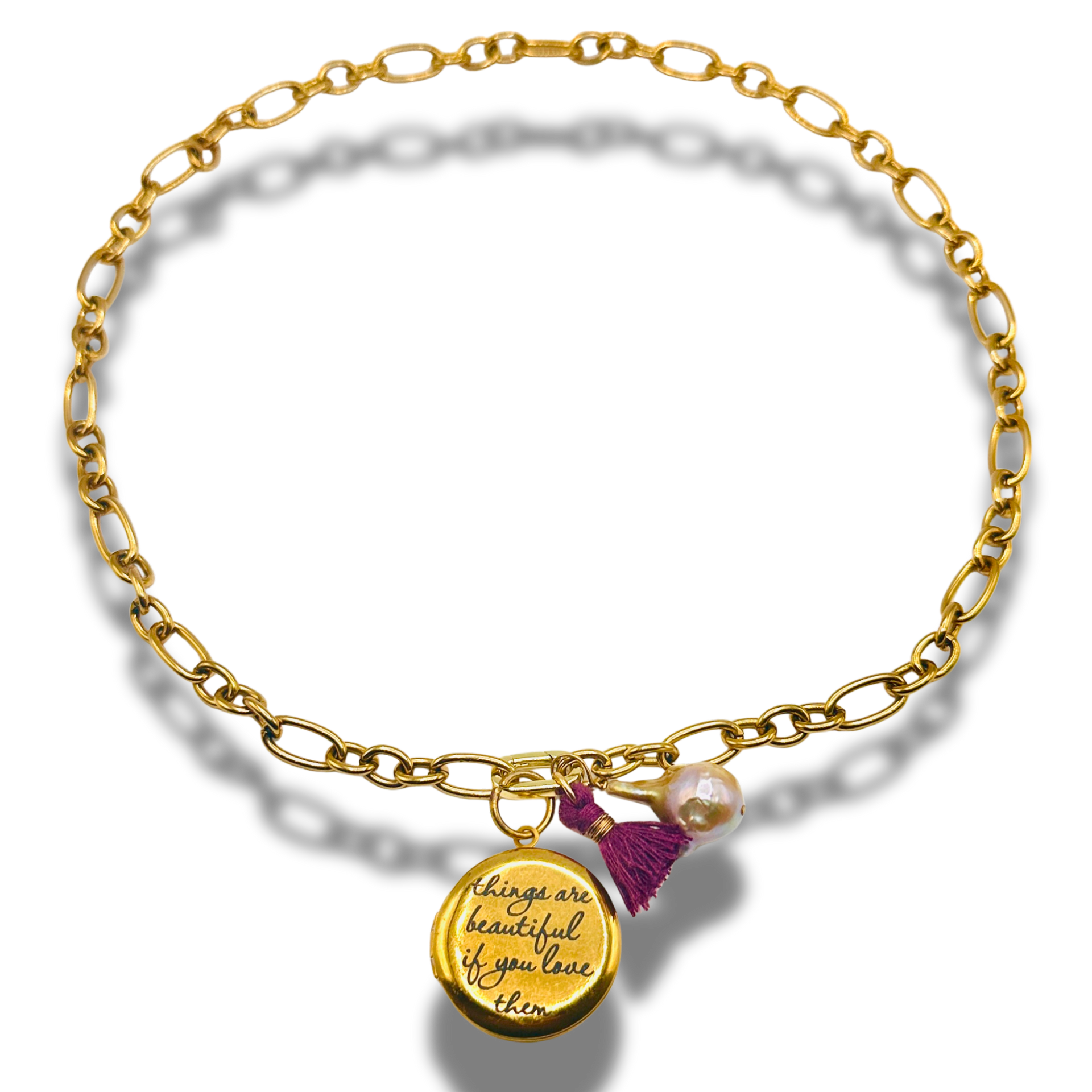 Gold bracelet with a charm and tassel on a white background