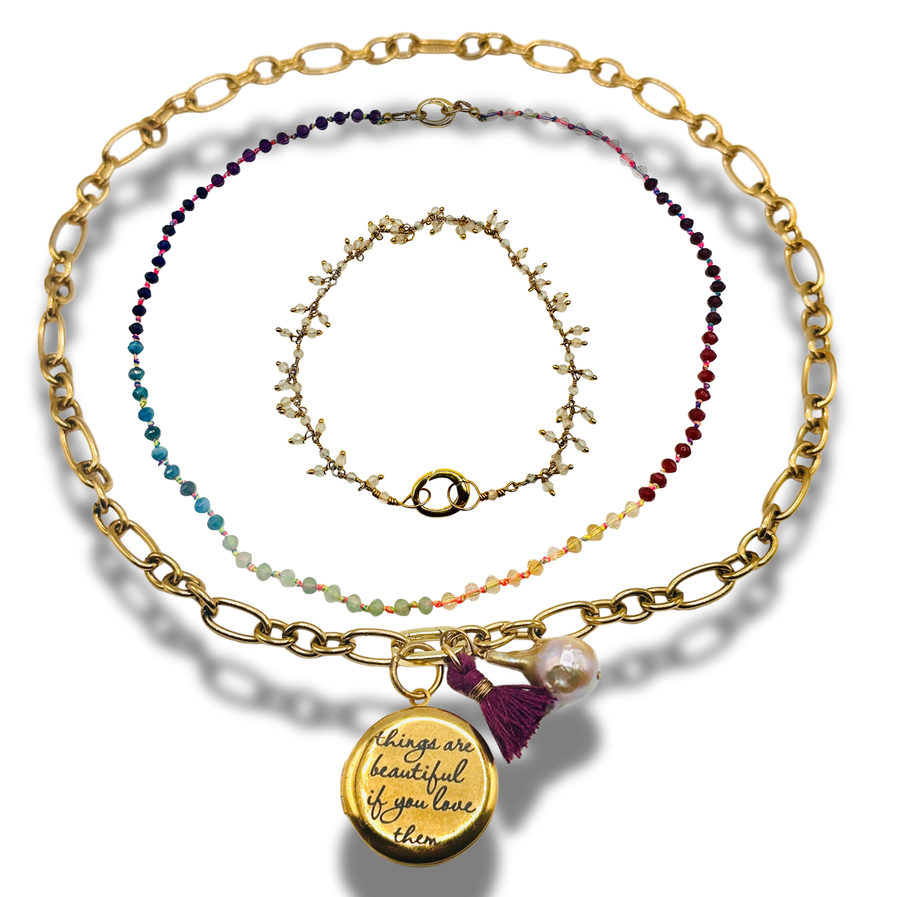 Set of gold and beaded necklaces on a white background