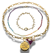 Set of gold and beaded necklaces on a white background