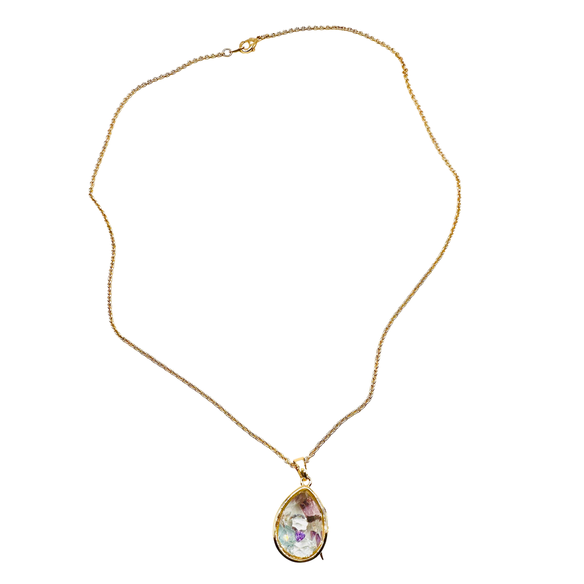 A gold chain necklace with a teardrop-shaped pendant containing a colorful, iridescent purple and green inlay, set against a plain white background.