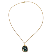 A gold chain necklace with an oval pendant featuring a dark green and blue marbled pattern surrounded by a gold border, shown against a plain white background.