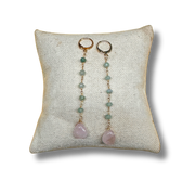 Pair of earrings with pink stones on a textured white pillow