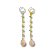 Pair of gold earrings with green beads and pink teardrop stones on a white background