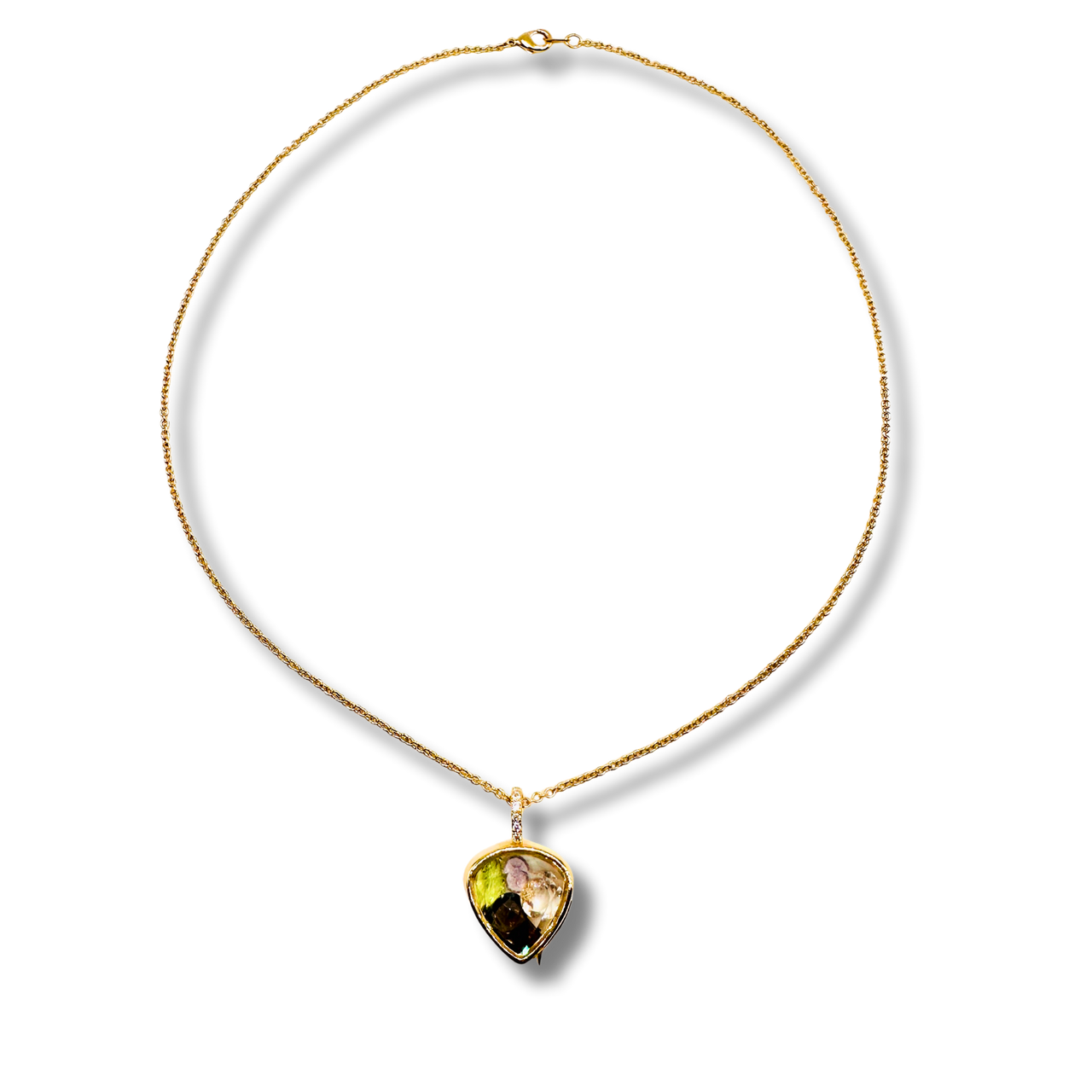 Gold necklace with a heart-shaped gemstone pendant on a white background