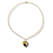 Gold necklace with a heart-shaped gemstone pendant on a white background