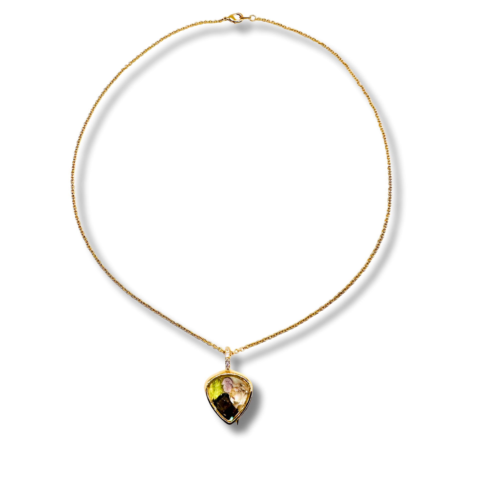 Gold necklace with a heart-shaped gemstone pendant on a white background