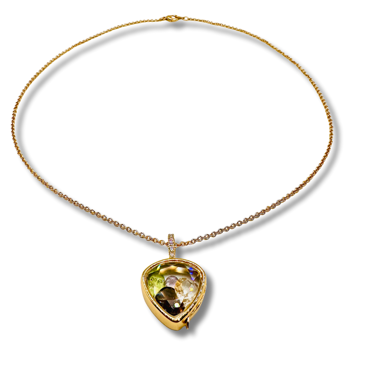 Gold necklace with a heart-shaped gemstone pendant on a white background