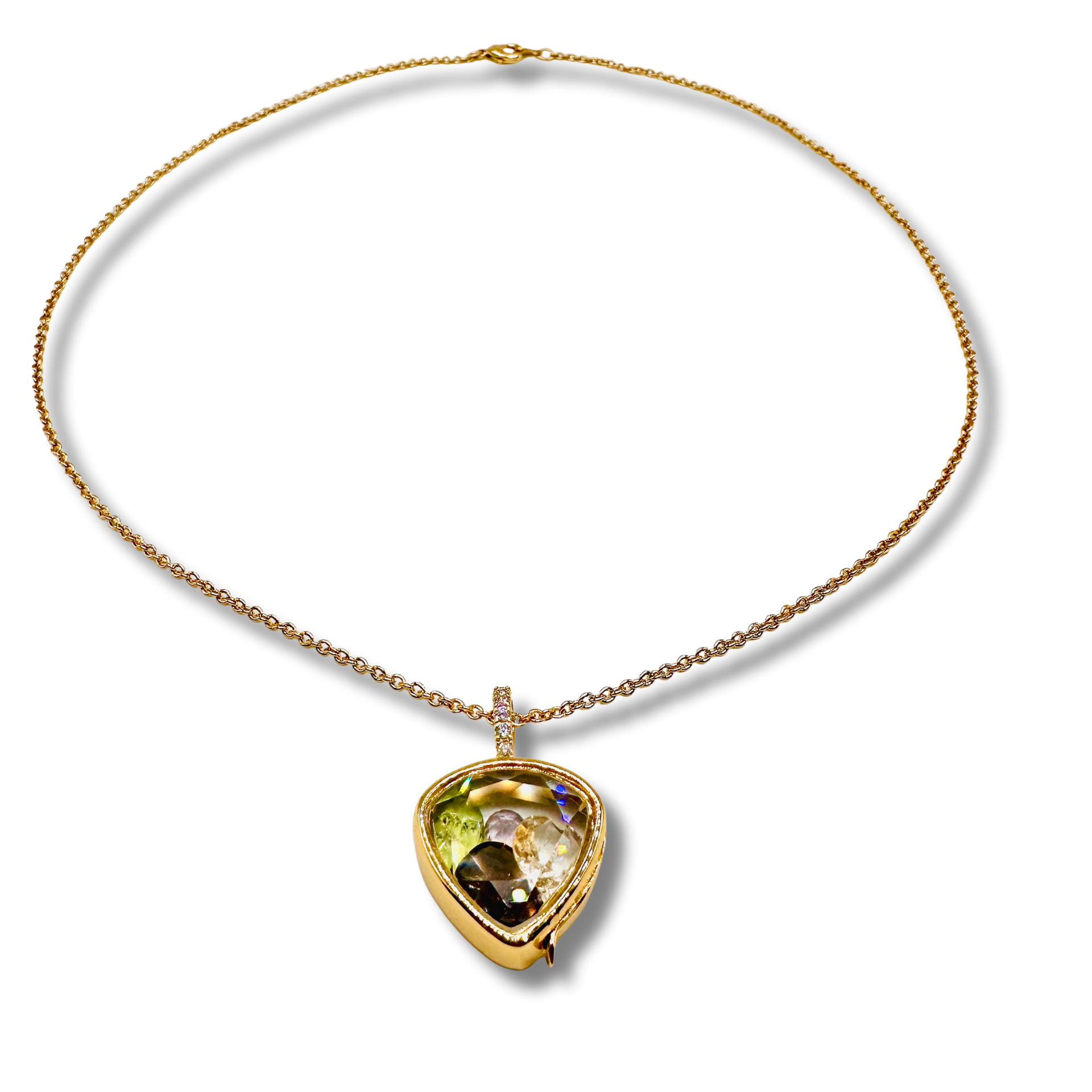 Gold necklace with a heart-shaped gemstone pendant on a white background