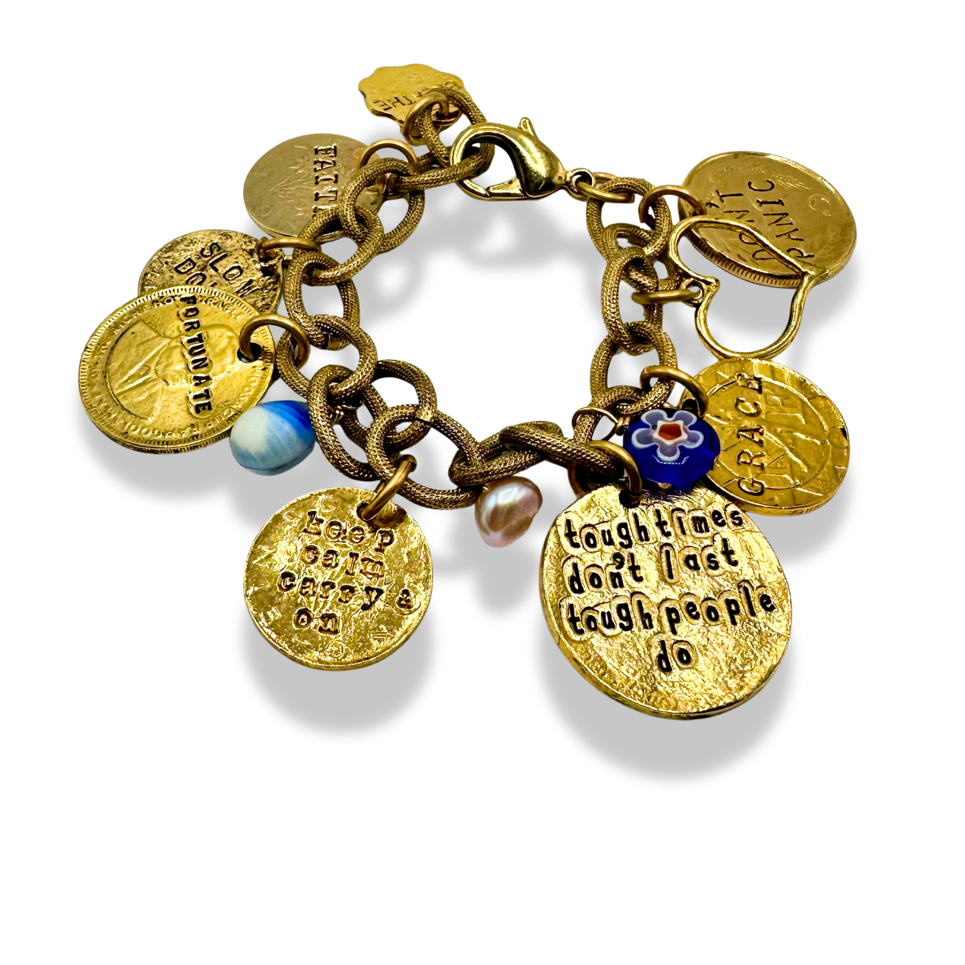 A gold-toned charm bracelet with multiple engraved round medallions, a blue and white bead, and a small blue floral charm, photographed on a white background.