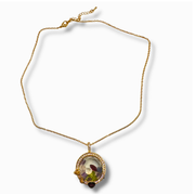 A gold chain necklace with a circular pendant featuring a colorful floral scene and small accent stones, displayed on a clean white background.