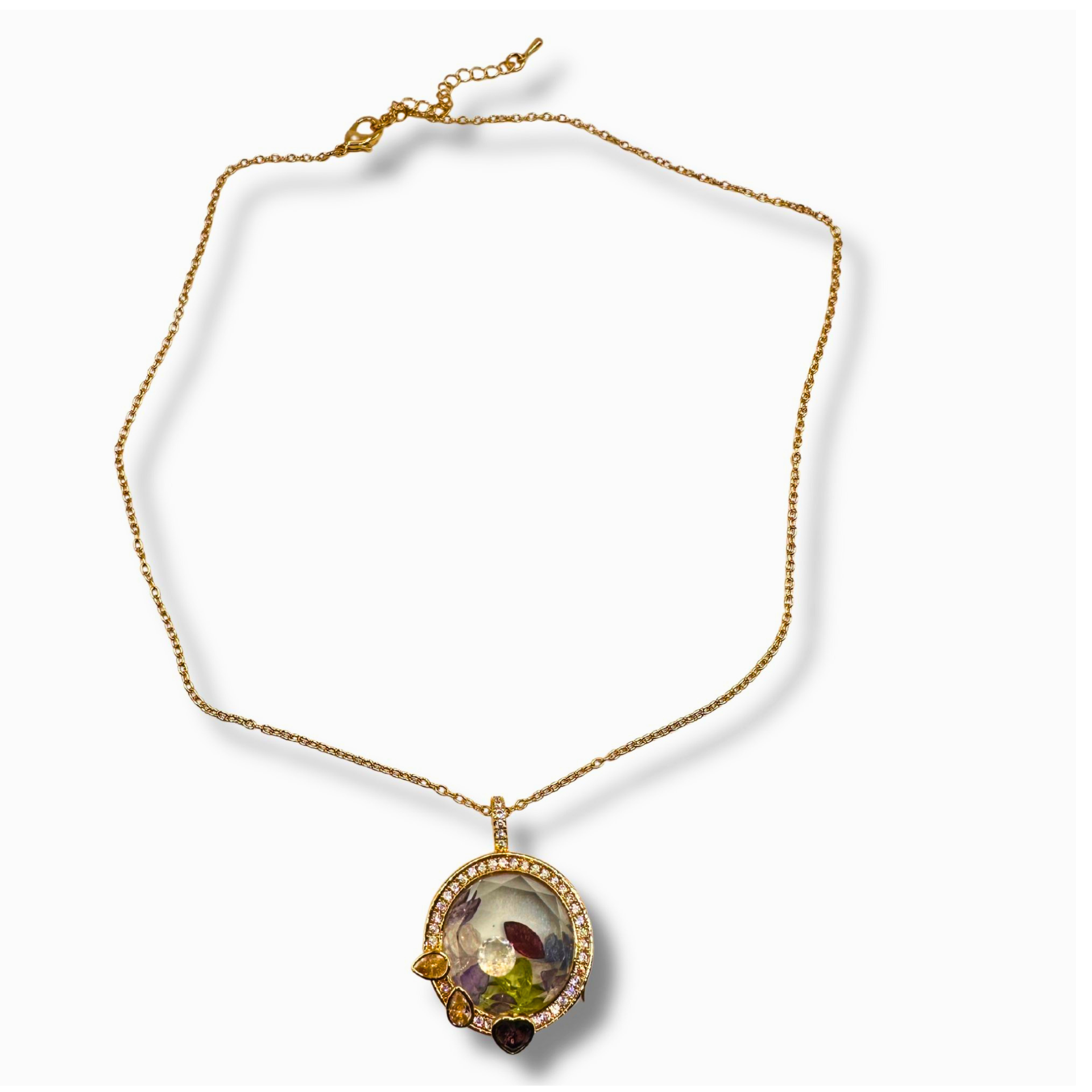 A gold chain necklace with a circular pendant featuring a colorful floral scene and small accent stones, displayed on a clean white background.