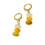 Pair of gold hoop earrings with yellow and white bead drops on a white background