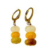 Pair of gold hoop earrings with multicolored bead drops on a white background