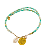 Multicolored beaded bracelet with gold charm and shell on a white background