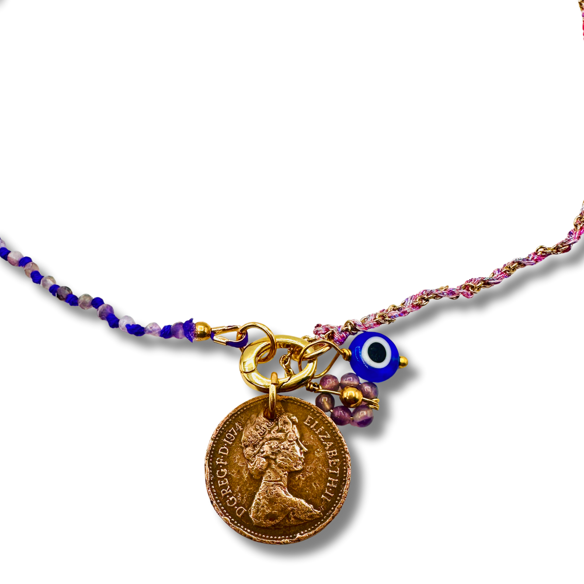 Necklace with a vintage coin charm and blue evil eye charm on a white background