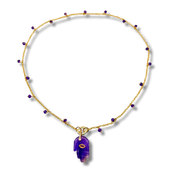 Necklace with purple pendant and gold chain on a white background