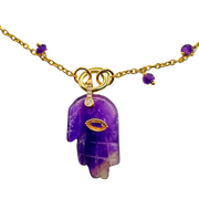 Purple crystal pendant necklace with gold accents on a white background