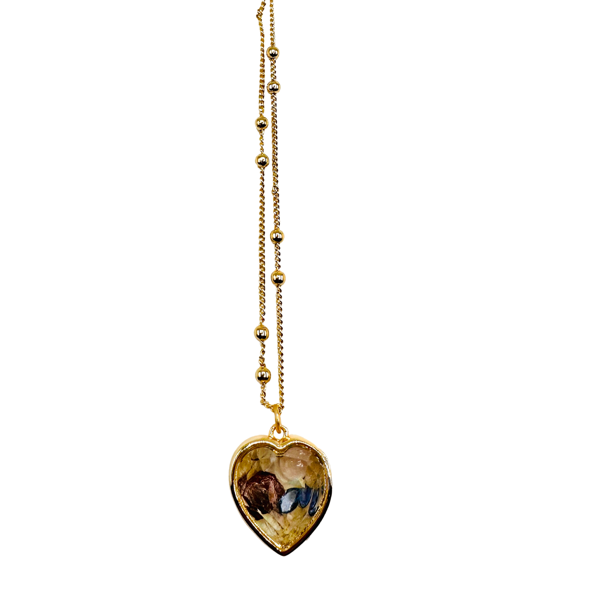 A gold heart-shaped pendant necklace featuring a detailed religious illustration of Saint Christopher carrying the Christ Child, suspended from a delicate gold beaded chain against a plain white background.