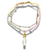 Multistrand beaded necklace with a crystal pendant on a white background