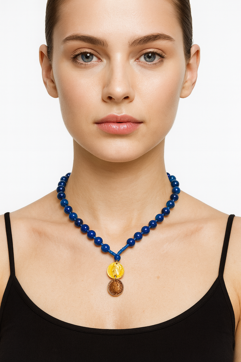 Woman wearing a blue beaded necklace with a yellow and brown pendant on a white background