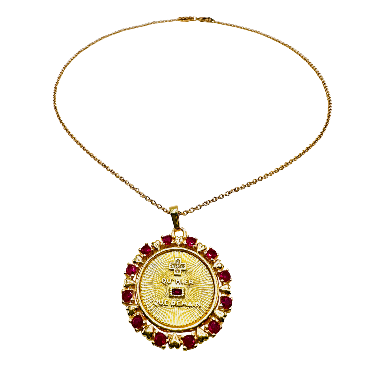 Gold necklace with a circular pendant featuring red stones on a white background