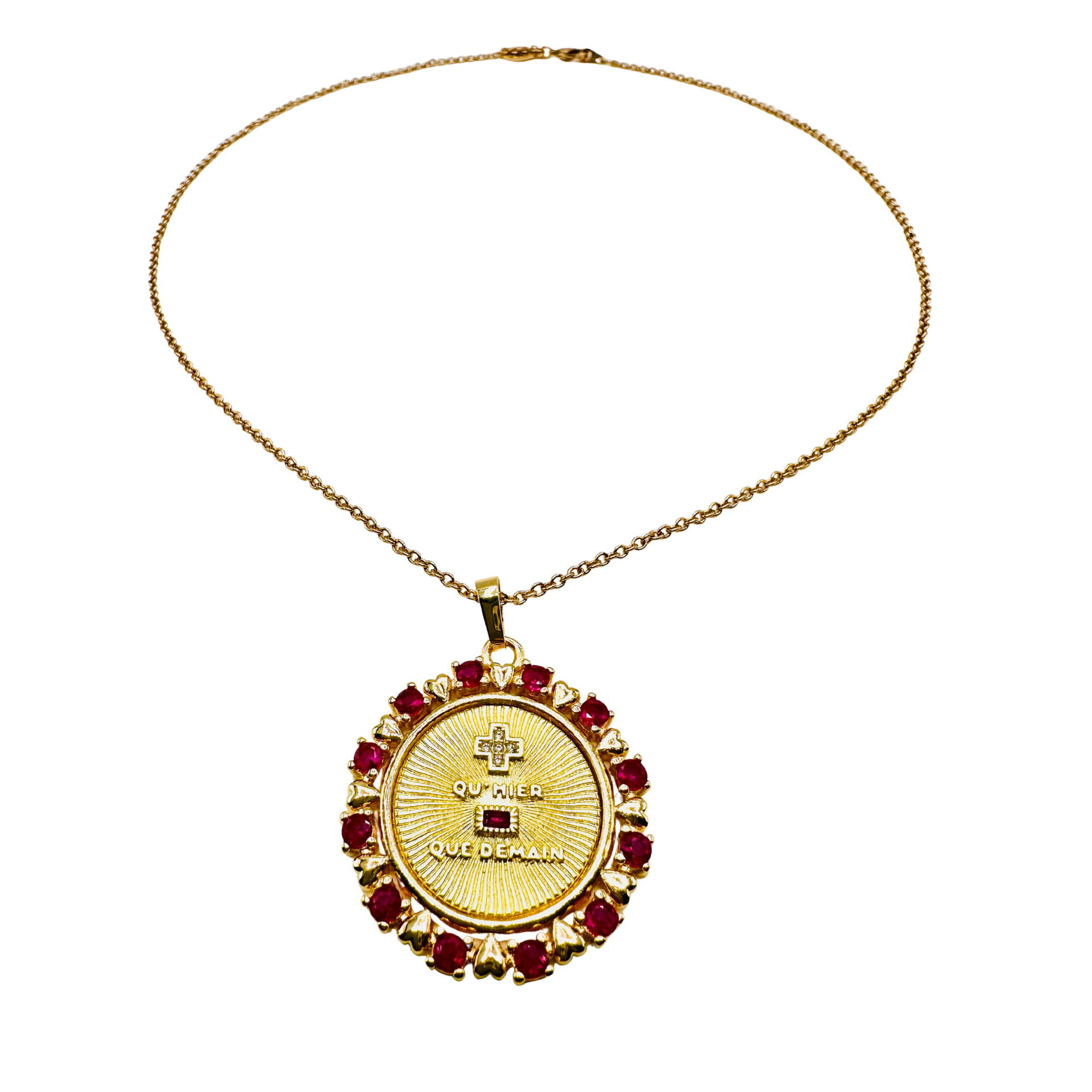 Gold necklace with a circular pendant featuring red stones on a white background
