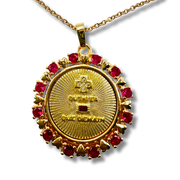 Gold pendant with red gemstones on a white background