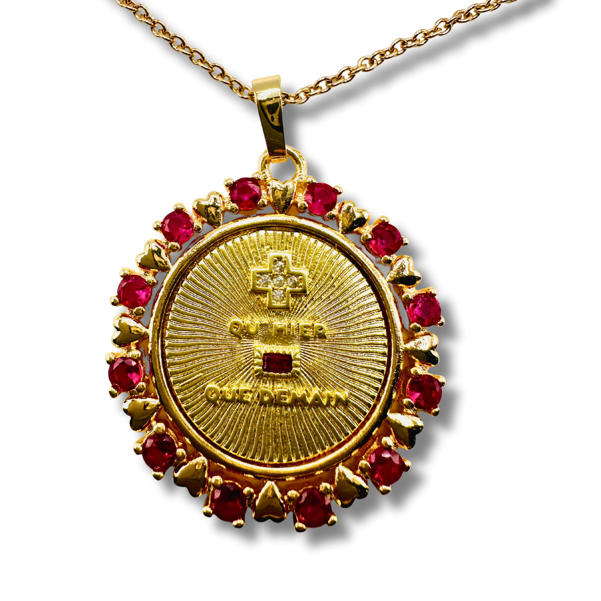 Gold pendant with red gemstones on a white background