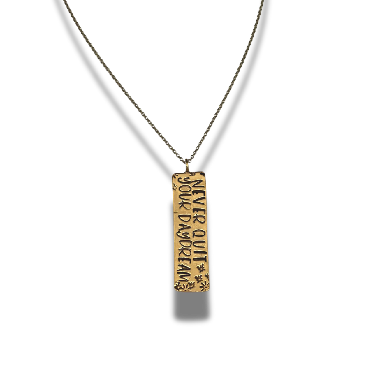 Gold pendant necklace with engraved text on a white background