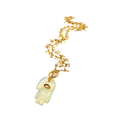Gold necklace with a Hamsa hand pendant on a white background