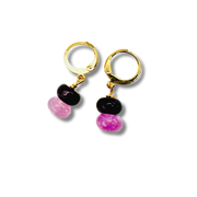 Pair of gold hoop earrings with black and pink beads on a white background