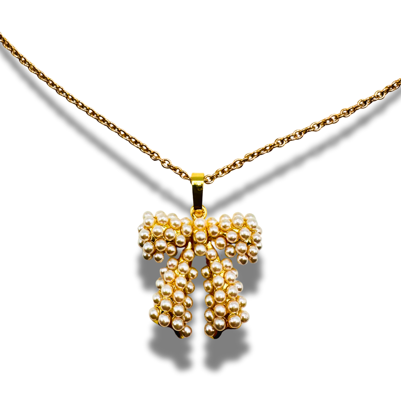 Gold necklace with a bow-shaped pendant on a white background