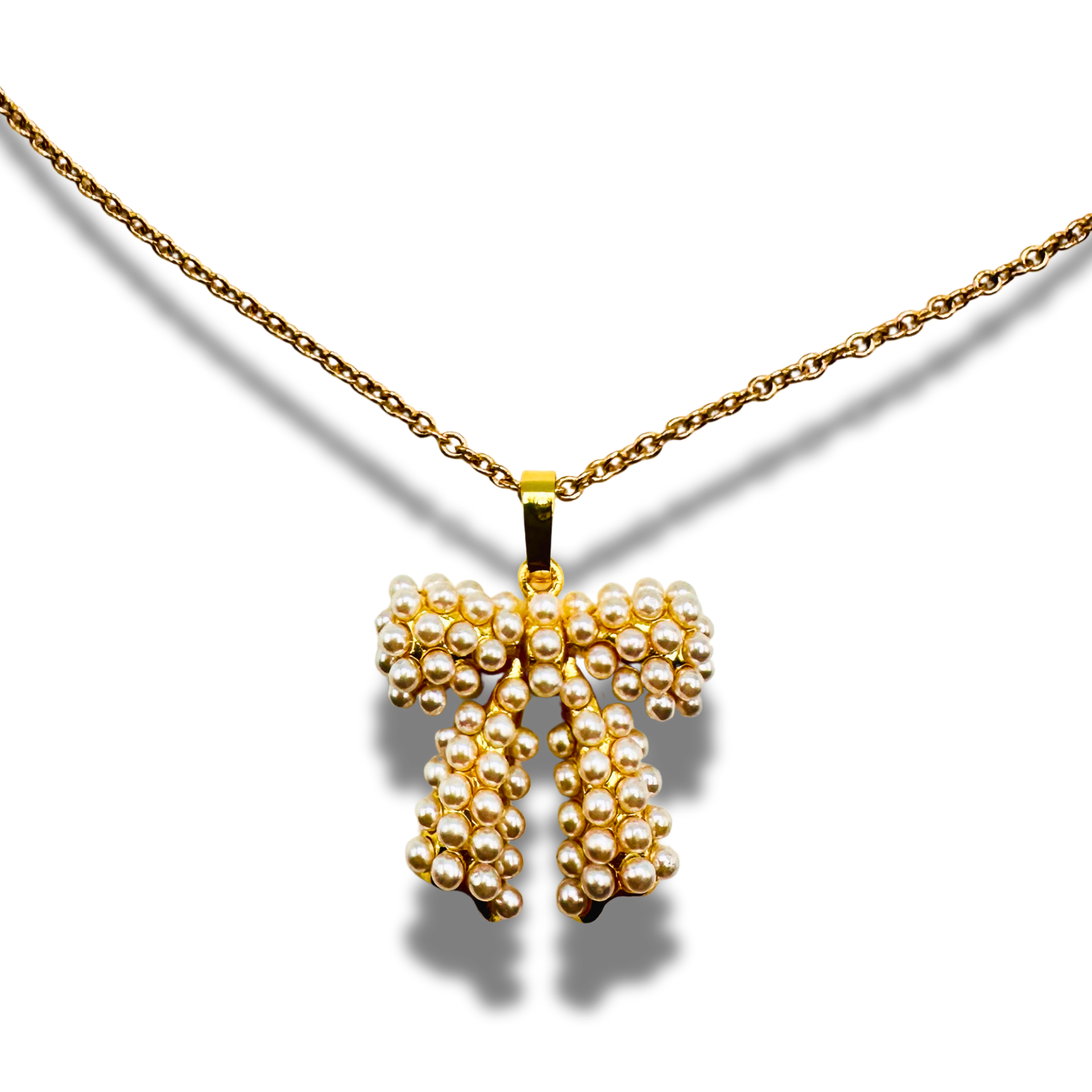 Gold necklace with a bow-shaped pendant on a white background