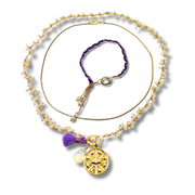 Gold necklace with a purple tassel and pendant on a white background