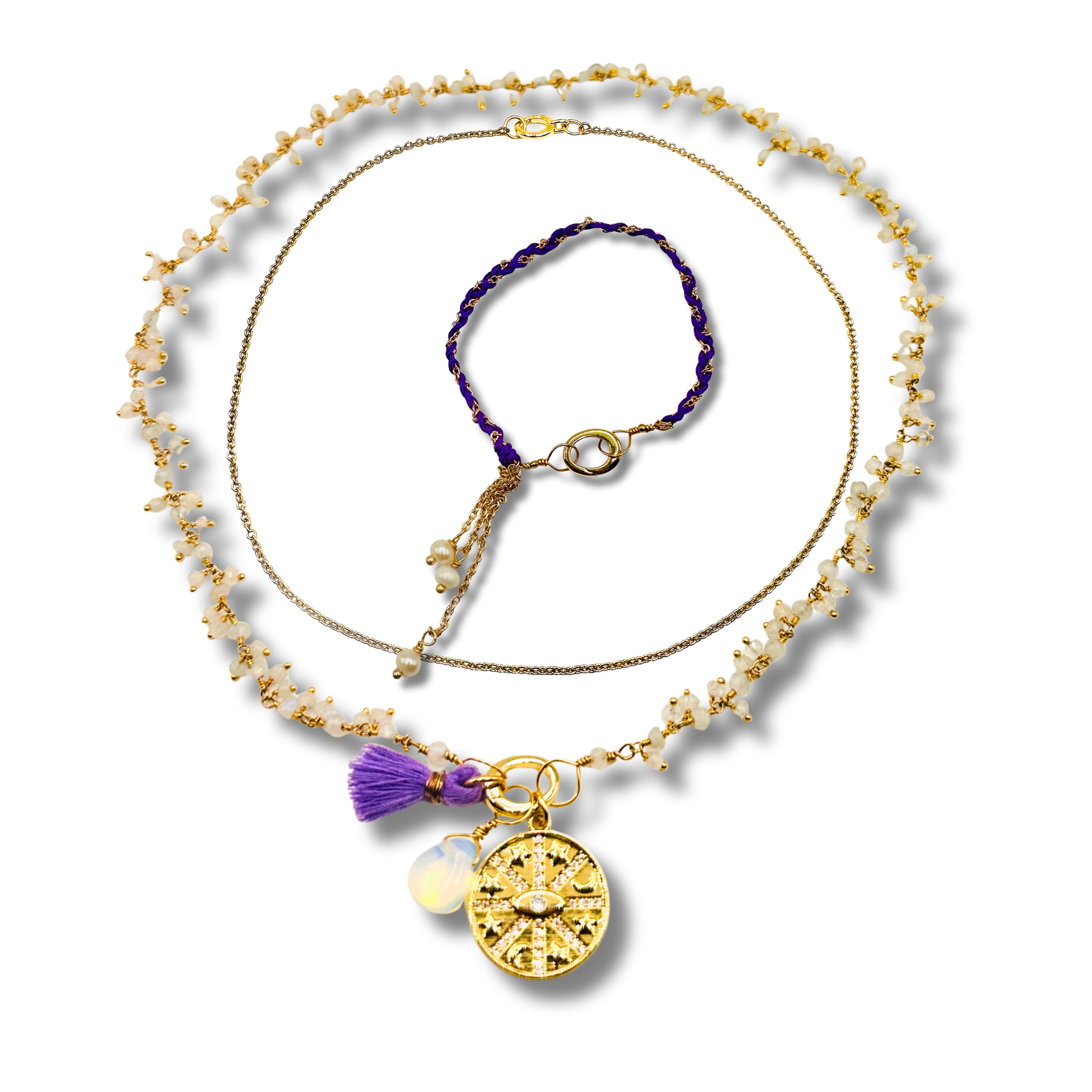 Gold necklace with a purple tassel and pendant on a white background
