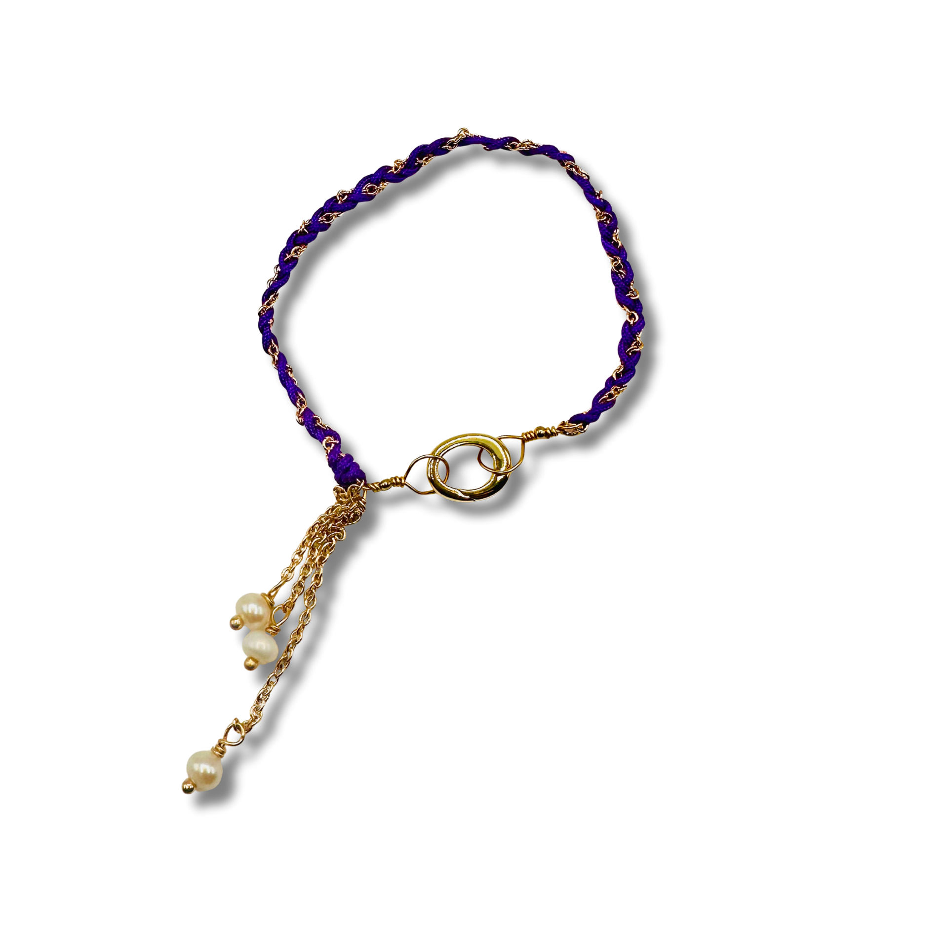 Purple beaded bracelet with gold accents and pearl charm on a white background