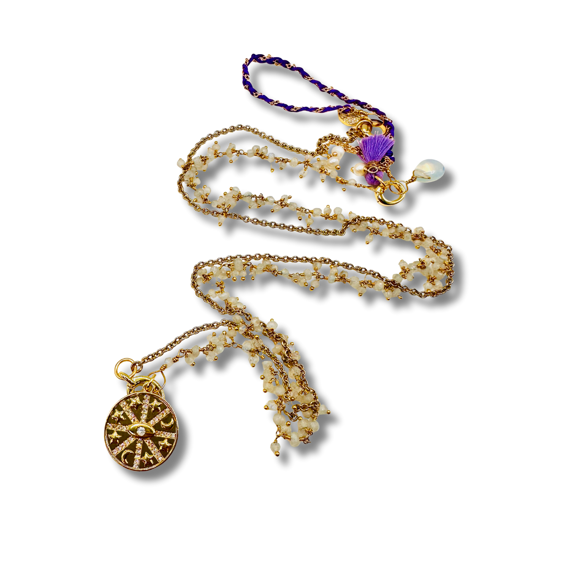 Gold necklace with various pendants on a white background